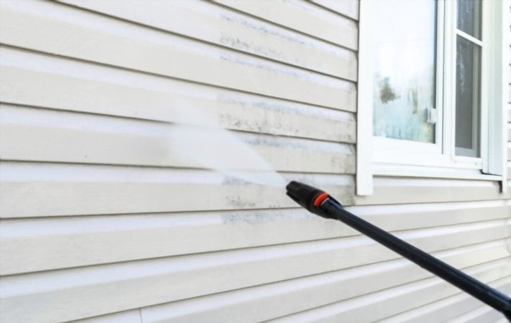 Professional pressure washing siding of home in Providence, FL