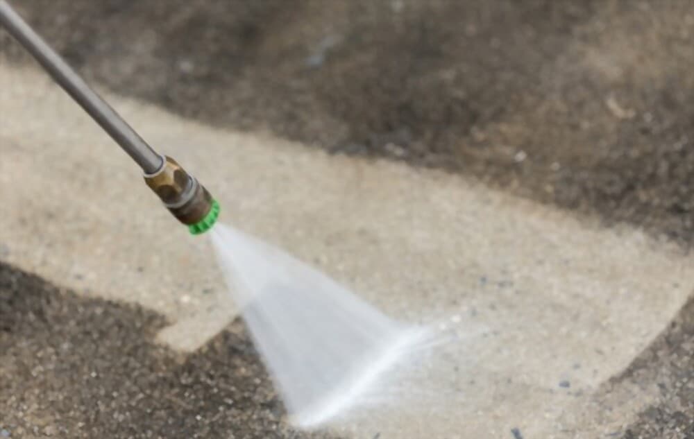 Up-close picture of pressure washing dirty driveway of Providence home, FL