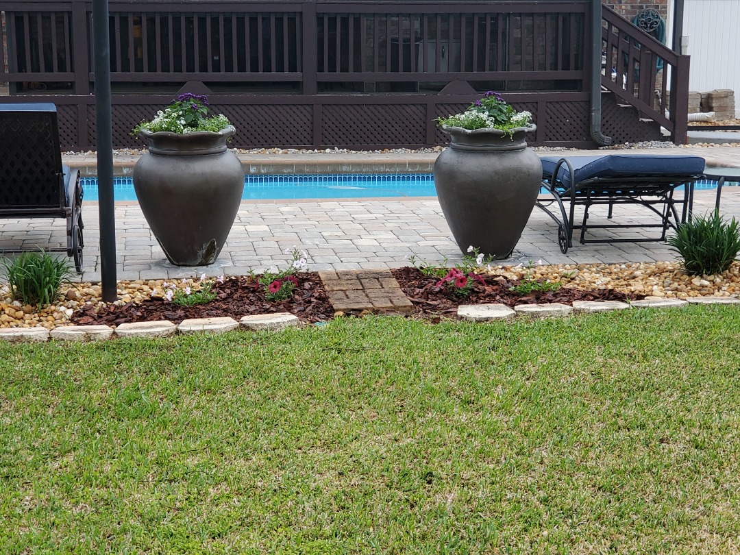 A gorgeous paver patio next to a pool.
.